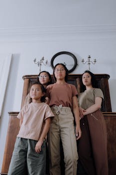 A portrait of four diverse sisters standing together indoors, showcasing unity and diversity.