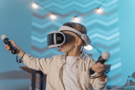 A young boy wearing VR goggles and playing with motion controllers in an indoor setting.